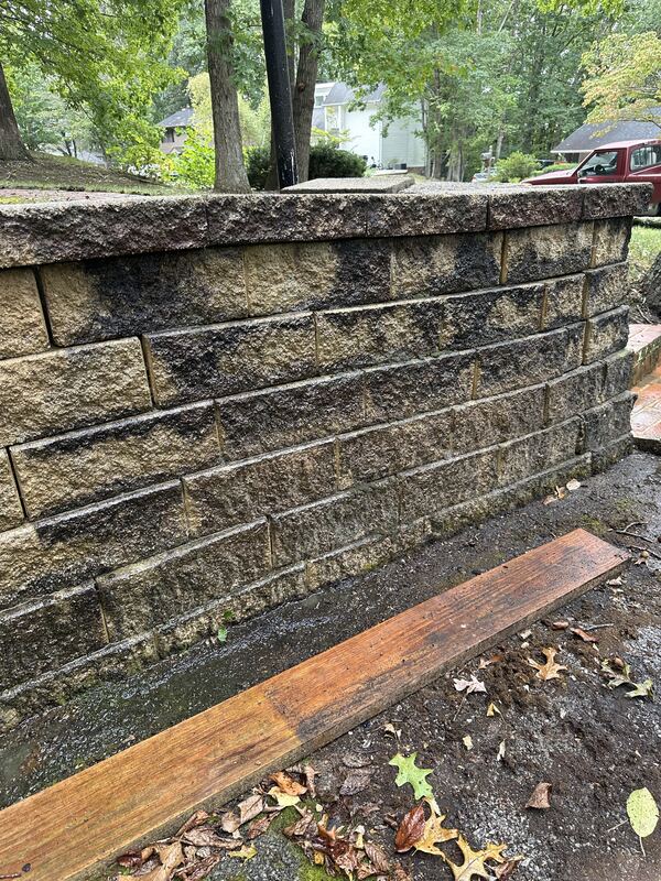 Stained retaining wall before pressure washing
